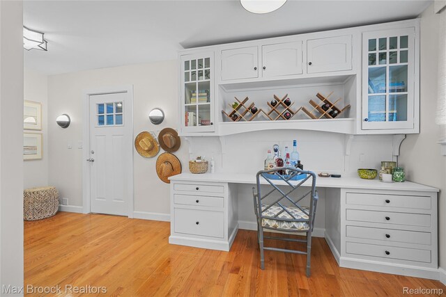 6863 Brightwood Ct, Waterford, MI 48327 - kitchen featuring white cabinets, light countertops, light wood-style flooring, glass insert cabinets, and baseboards