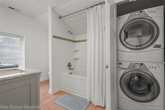 6863 Brightwood Ct, Waterford, MI 48327 - laundry area featuring stacked washer / drying machine, light wood finished floors, and baseboards