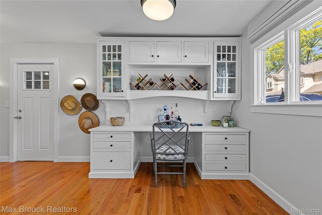 6863 Brightwood Ct, Waterford, MI 48327 - office area with built in desk, light wood finished floors, and baseboards