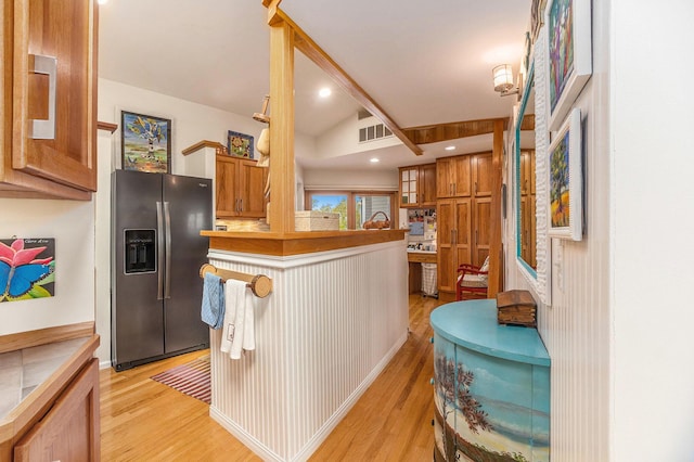 6180 Murray Rd Unit 301, Whitehall, MI 49461 - kitchen featuring stainless steel refrigerator with ice dispenser, light wood finished floors, brown cabinets, a peninsula, and vaulted ceiling