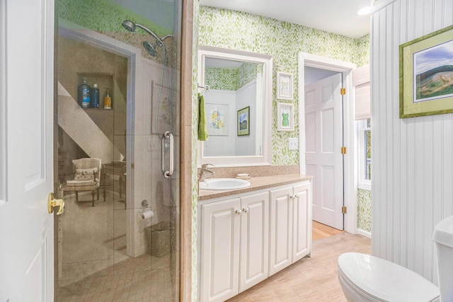 6180 Murray Rd Unit 301, Whitehall, MI 49461 - full bathroom with wallpapered walls, a stall shower, vanity, toilet, and wood finished floors