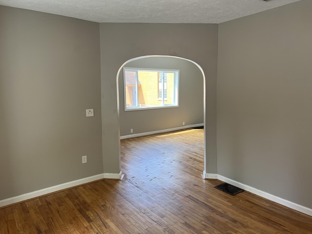 911 Muskegon Ave NW, Grand Rapids, MI 49504 - spare room featuring wood finished floors, baseboards, and a textured ceiling