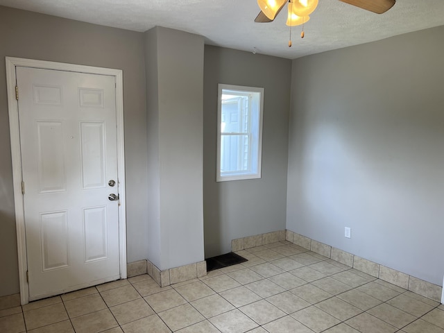 911 Muskegon Ave NW, Grand Rapids, MI 49504 - spare room featuring light tile patterned flooring, a ceiling fan, a textured ceiling, and baseboards