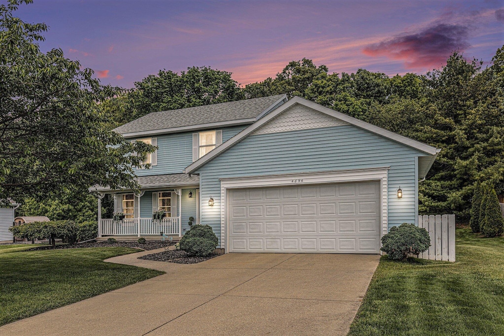 4896 Cedar Crest Ct NE, Grand Rapids, MI 49525 - traditional home with a porch, a garage, concrete driveway, and a front yard