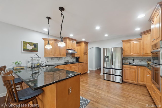 9120 Pineview Lake Dr, Linden, MI 48451 - kitchen featuring appliances with stainless steel finishes, arched walkways, a peninsula, tasteful backsplash, and recessed lighting