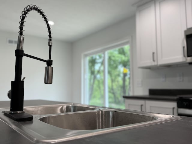 2827 Green Acres Dr, Mulliken, MI 48861 - kitchen view of white cabinetry and dark countertops