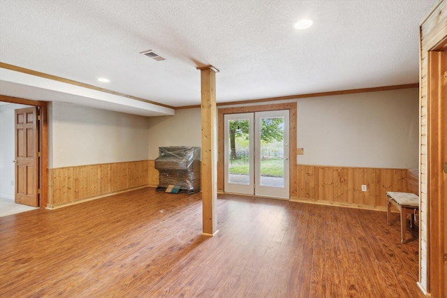 1750 Fox Rd, Jackson, MI 49201 - below grade area featuring a wainscoted wall, wood walls, wood finished floors, and a textured ceiling