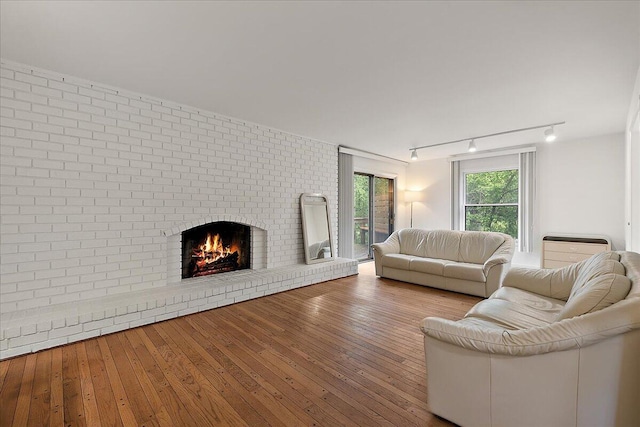 4948 Hardwoods Dr, West Bloomfield, MI 48323 - living room featuring rail lighting, a brick fireplace, and hardwood / wood-style flooring