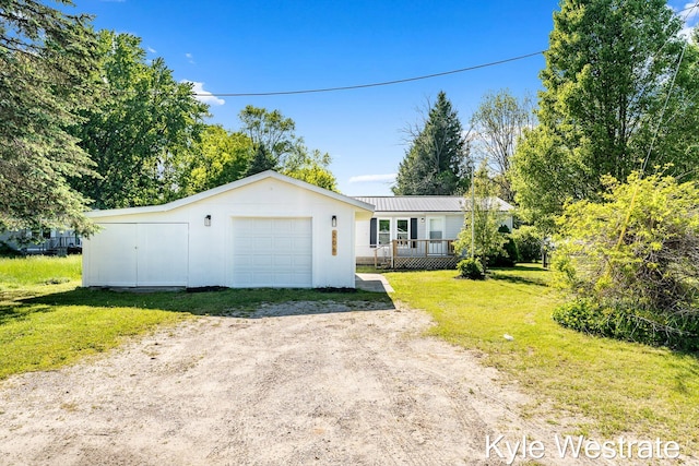 206 Pearl St, Sheridan, MI 48884 - ranch-style home featuring an outdoor structure, driveway, a garage, a front lawn, and a deck
