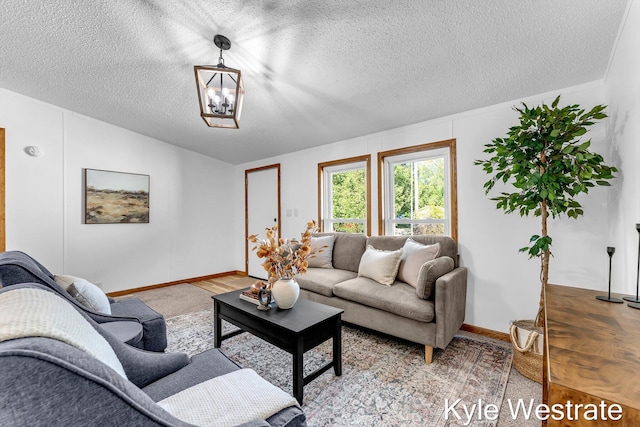 206 Pearl St, Sheridan, MI 48884 - living area with baseboards, a textured ceiling, and a chandelier