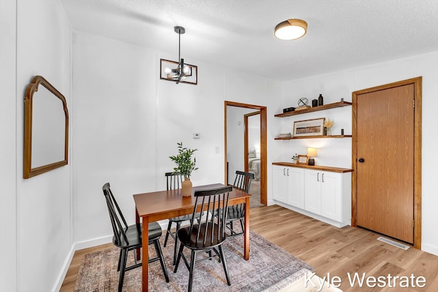 206 Pearl St, Sheridan, MI 48884 - dining area featuring light wood-type flooring and a chandelier