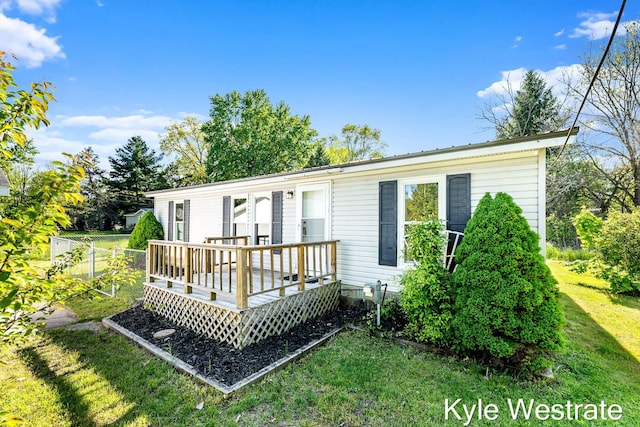 206 Pearl St, Sheridan, MI 48884 - view of front of house featuring a wooden deck and a front lawn