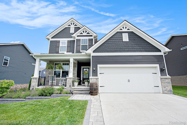 2670 Ironton Dr, Commerce Twp, MI 48382 - craftsman house with stone siding, covered porch, driveway, and a front lawn