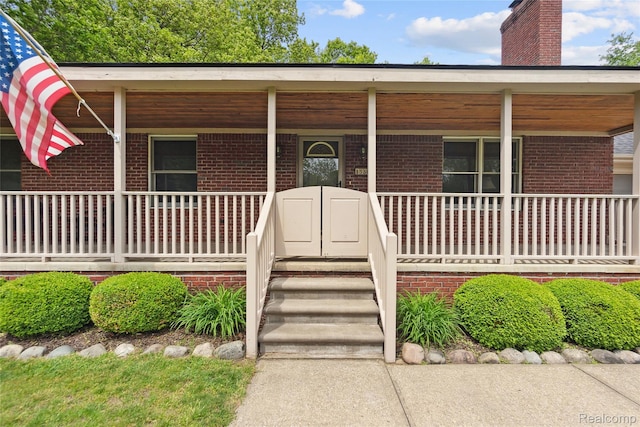 1330 Evergreen, Milford, MI 48380 - view of front of home with covered porch, brick siding, and a chimney