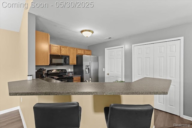 51623 Hale Ln, Chesterfield, MI 48051 - kitchen with black appliances, dark countertops, and a kitchen bar