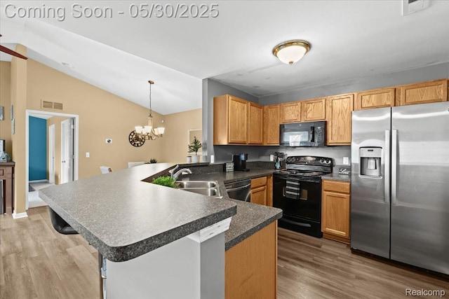 51623 Hale Ln, Chesterfield, MI 48051 - kitchen with black appliances, a sink, a peninsula, light wood finished floors, and vaulted ceiling