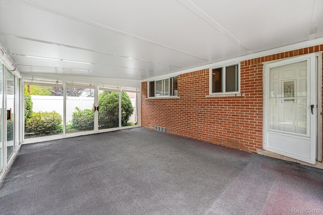 6439 Rockdale Ct, Dearborn Heights, MI 48127 - unfurnished sunroom featuring brick wall and carpet floors