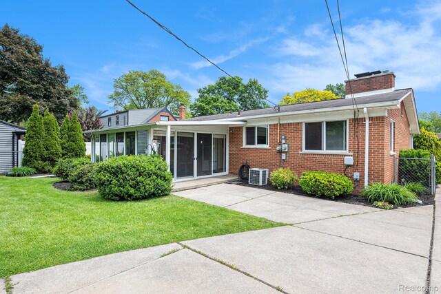 6439 Rockdale Ct, Dearborn Heights, MI 48127 - rear view of house featuring a chimney, central AC, brick siding, and a sunroom