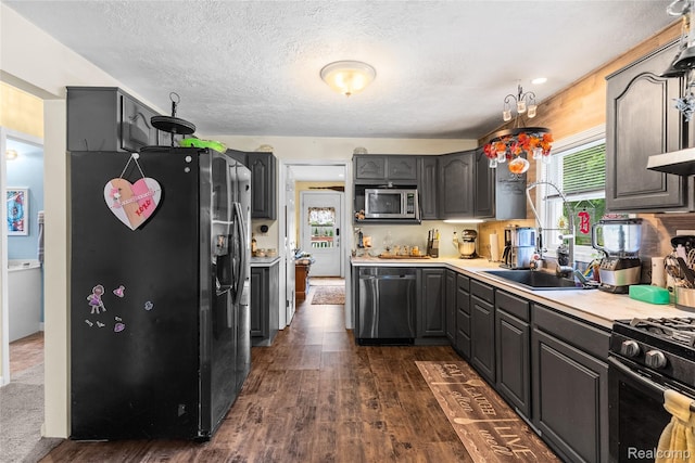 306 Hamilton St, Byron, MI 48418 - kitchen with stainless steel appliances, dark wood finished floors, light countertops, a textured ceiling, and gray cabinetry