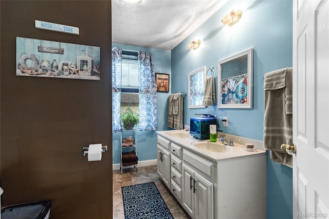 306 Hamilton St, Byron, MI 48418 - bathroom featuring double vanity, a textured ceiling, and baseboards