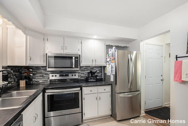 6716 Cascade Rd SE, Grand Rapids, MI 49546 - kitchen featuring appliances with stainless steel finishes, a sink, backsplash, and white cabinetry