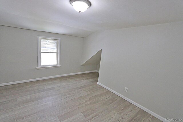 19444 Inkster Rd, Redford, MI 48240 - empty room featuring vaulted ceiling, light wood-type flooring, and baseboards