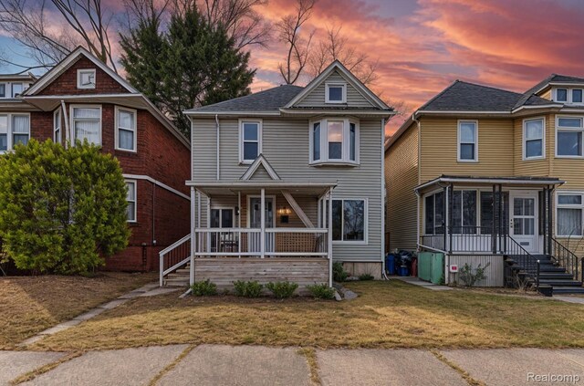 2547 Seyburn St, Detroit, MI 48214 - view of front of house with a porch, a lawn, and a sunroom