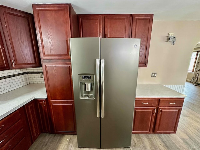 13405 S Gera Rd, Birch Run, MI 48415 - kitchen featuring stainless steel fridge, light wood-style floors, reddish brown cabinets, light countertops, and backsplash