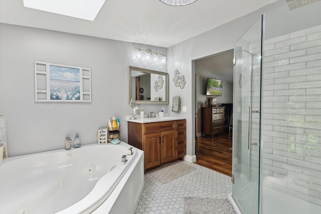 5885 Lammers Rd, Hastings, MI 49058 - full bath featuring vanity, a whirlpool tub, a stall shower, a skylight, and tile patterned floors