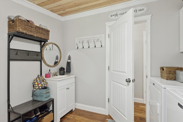 5885 Lammers Rd, Hastings, MI 49058 - washroom featuring washer and clothes dryer, cabinet space, wood finished floors, crown molding, and baseboards