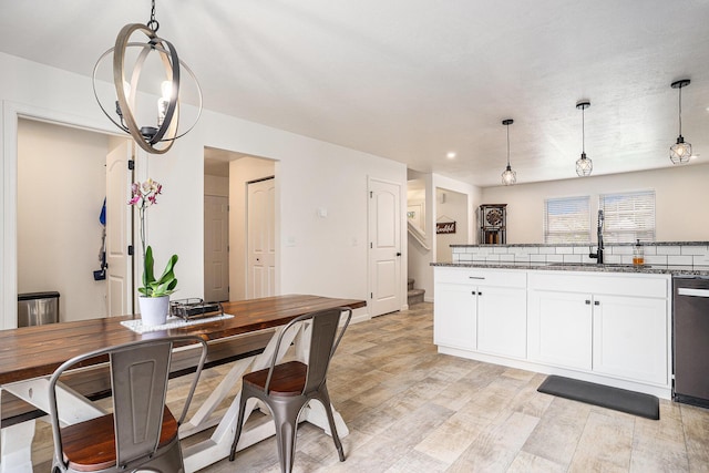 10900 Vine Leaf Cir, Allendale, MI 49401 - kitchen with dishwasher, dark stone countertops, white cabinetry, a sink, and hanging light fixtures