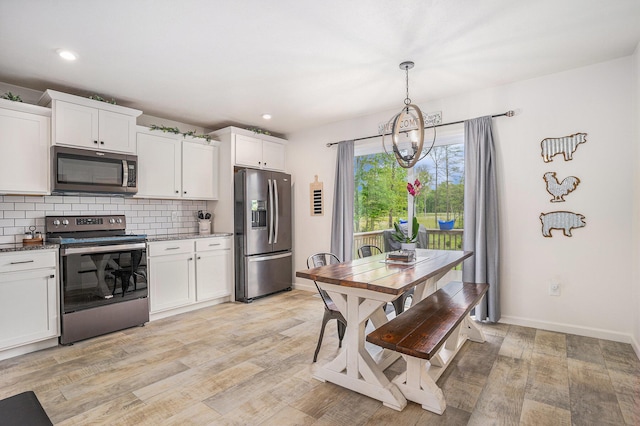 10900 Vine Leaf Cir, Allendale, MI 49401 - kitchen featuring stainless steel appliances, decorative backsplash, light wood-type flooring, white cabinets, and pendant lighting