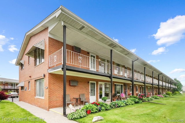 2125 Clawson Ave Unit 207, Royal Oak, MI 48073 - rear view of house with a balcony, brick siding, and a yard