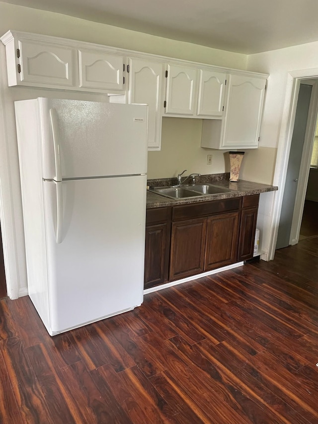 2194 E Bristol Rd, Burton, MI 48529 - kitchen with freestanding refrigerator, a sink, dark countertops, and dark wood-style floors