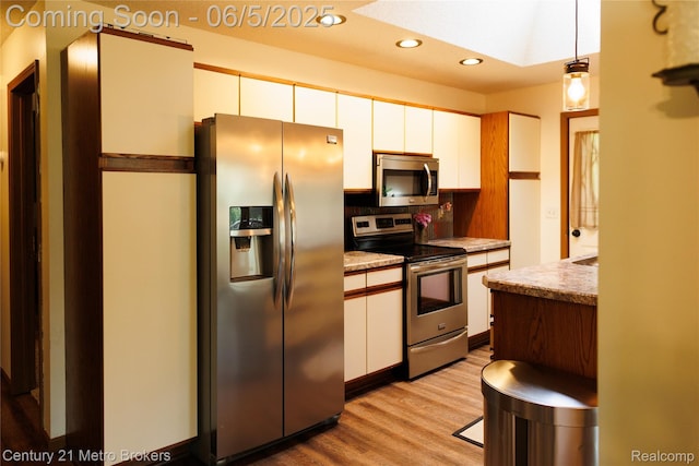 4447 Stanley Rd, Genesee, MI 48437 - kitchen featuring appliances with stainless steel finishes, white cabinetry, light wood-style flooring, a skylight, and recessed lighting