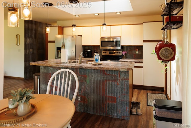 4447 Stanley Rd, Genesee, MI 48437 - kitchen with appliances with stainless steel finishes, dark wood finished floors, a kitchen island with sink, backsplash, and white cabinets