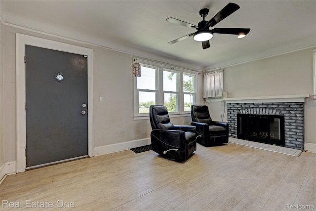86 Marquette St, Pontiac, MI 48342 - sitting room featuring ceiling fan, wood finished floors, a brick fireplace, baseboards, and crown molding