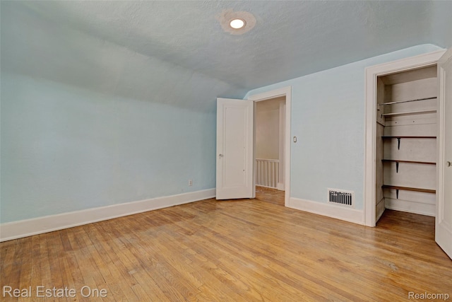 86 Marquette St, Pontiac, MI 48342 - unfurnished bedroom with baseboards, lofted ceiling, light wood-style flooring, a walk in closet, and a closet