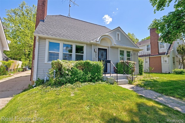 86 Marquette St, Pontiac, MI 48342 - view of front of house featuring a chimney, a front lawn, and roof with shingles