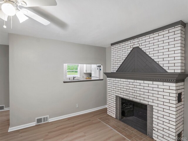 5220 County Line Rd, Lenox, MI 48048 - unfurnished living room with wood finished floors, baseboards, ceiling fan, and a fireplace