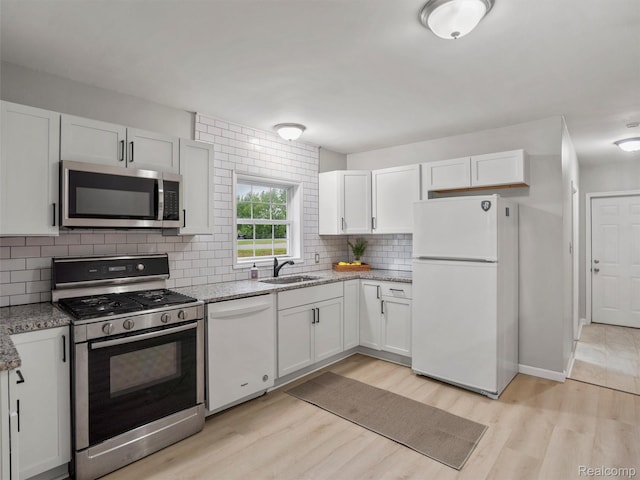 5220 County Line Rd, Lenox, MI 48048 - kitchen featuring stainless steel appliances, a sink, light wood finished floors, backsplash, and light stone counters