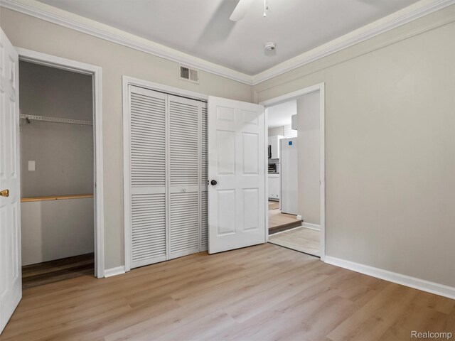 5220 County Line Rd, Lenox, MI 48048 - unfurnished bedroom with freestanding refrigerator, light wood finished floors, ornamental molding, multiple closets, and baseboards
