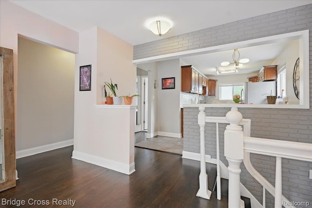 23850 Barfield St, Farmington, MI 48336 - dining space with dark wood finished floors, baseboards, and brick wall