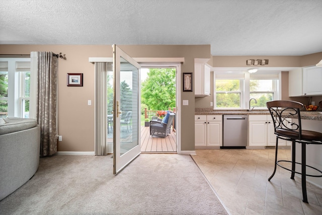 4388 Lori Lynn Ln, Whitmore Lake, MI 48189 - kitchen with dishwasher, white cabinetry, a textured ceiling, a sink, and baseboards