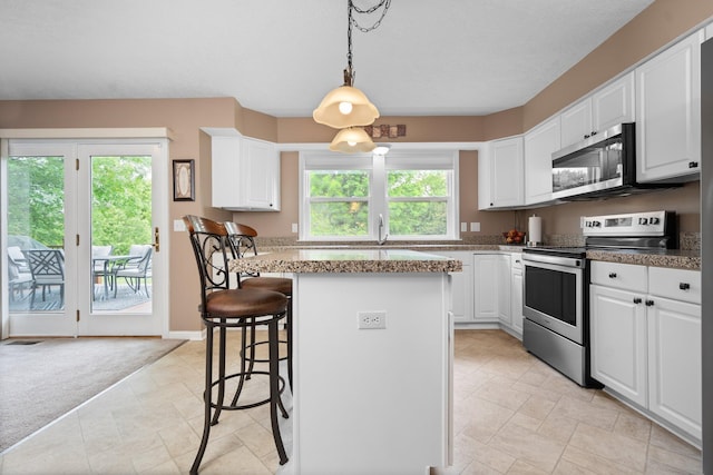 4388 Lori Lynn Ln, Whitmore Lake, MI 48189 - kitchen with stainless steel appliances, a kitchen bar, a kitchen island, and white cabinetry