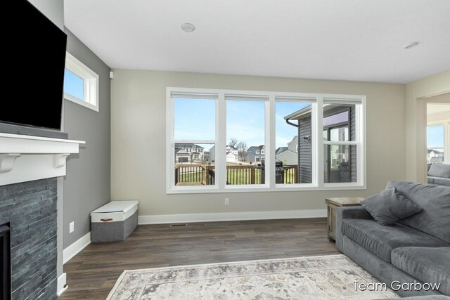 1757 Julienne Ct, Byron Center, MI 49315 - living room featuring a glass covered fireplace, wood finished floors, and baseboards