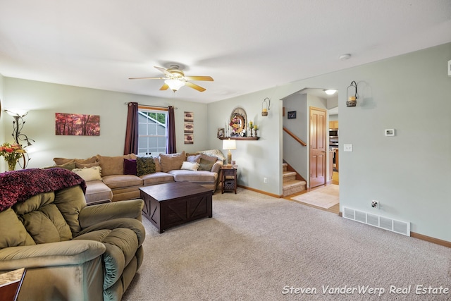 2567 Chippewa Trl, Muskegon, MI 49445 - living area featuring a ceiling fan, light colored carpet, arched walkways, and stairway