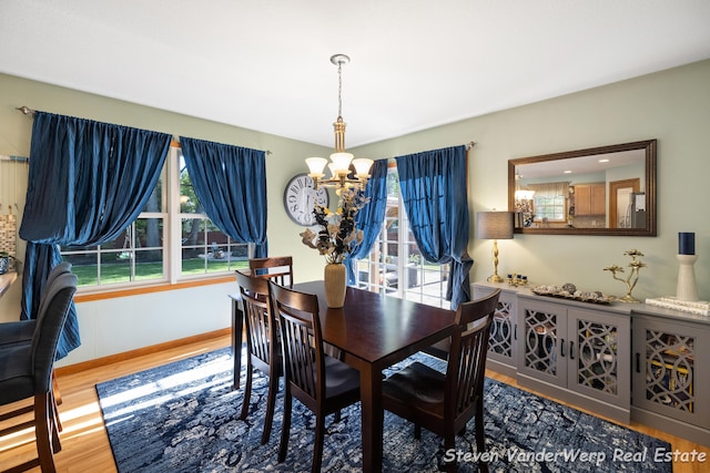 2567 Chippewa Trl, Muskegon, MI 49445 - dining room featuring a chandelier, wood finished floors, and baseboards