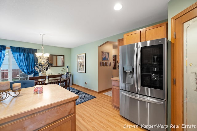 2567 Chippewa Trl, Muskegon, MI 49445 - kitchen with stainless steel fridge, light wood-style floors, a chandelier, light countertops, and decorative light fixtures