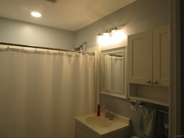 736 State St, Adrian, MI 49221 - bathroom with vanity, a shower with curtain, toilet, and recessed lighting